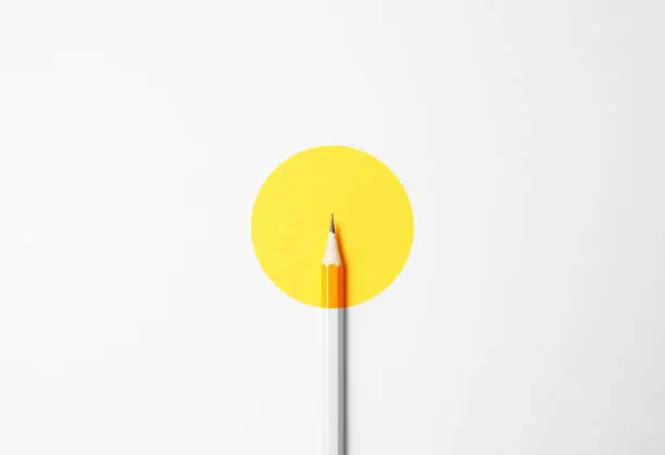 Photo of Yellow pencil on a white background, minimalism. Abstract art, imagination, education