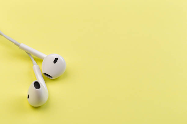 istock white earphones on yellow background 1129792266