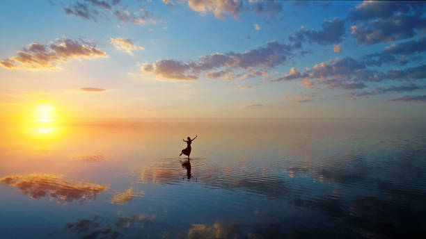istock Ballerina dancing on the lake at sunset. 1129793706