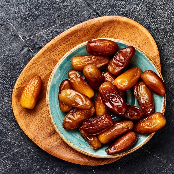 istock Dried dates fruits on plate. Top view of pitted dates. 1129794371