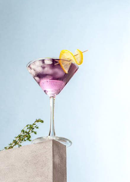 Cold cocktail with lavender syrup and lemon with ice on a light blue background. stock photo