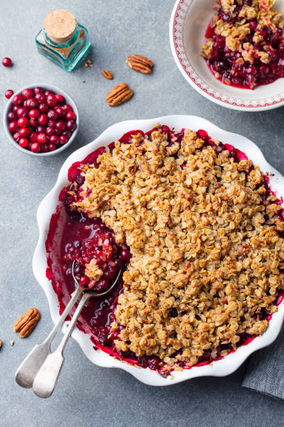 Cranberry crumble, crisp in a baking dish. Grey background. Top view. Cranberry crumble, crisp in a baking dish. Grey background. Top view cobbler dessert stock pictures, royalty-free photos & images