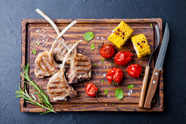 istock Lamb ribs grilled on cutting board with roasted vegetables. Top view. 1129798107