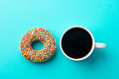Coffee with donut on blue background. Top view.
