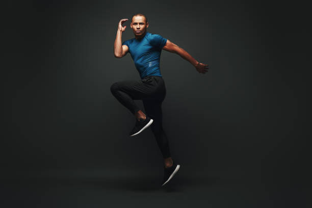 istock Pushing hard to win. Sportsman jumping over dark background 1129798455