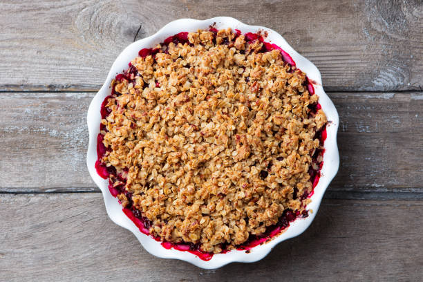 istock Berry crumble, crisp in baking dish. Wooden background. Top view. 1129798499