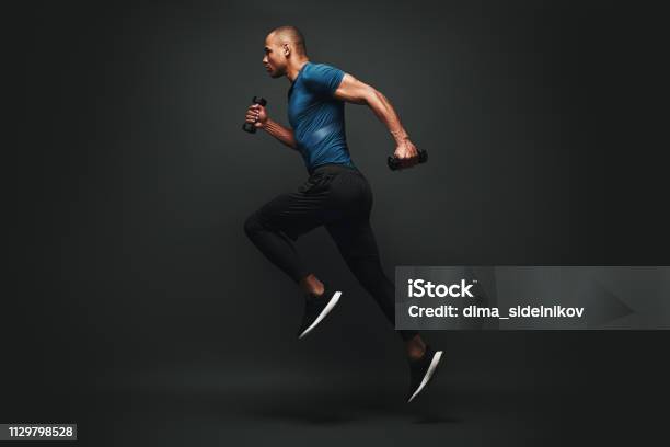 Everything You Ve Ever Wanted Is On The Other Side Of Fear Dark Skinned Sportsman Jumping Over Dark Background He Is Ready To Run Stock Photo - Download Image Now