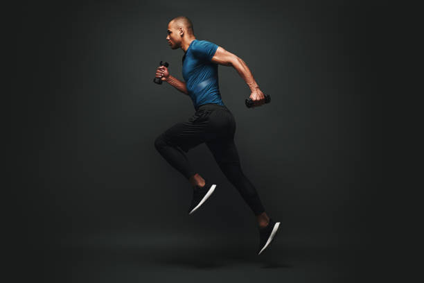 everything you ve ever wanted is on the other side of fear. dark skinned sportsman jumping over dark background. he is ready to run - shirt ethnic ethnicity one person imagens e fotografias de stock