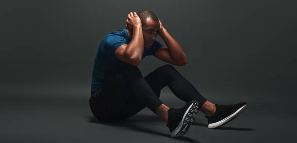 istock Concentrate on your goals. Sportsman lying over dark background, working abs 1129798570