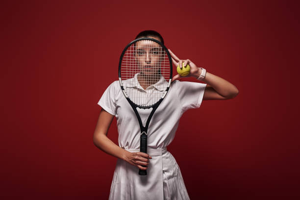 istock Refuse to Lose Young tennis player standing isolated over red background with a racket and a ball 1129798624