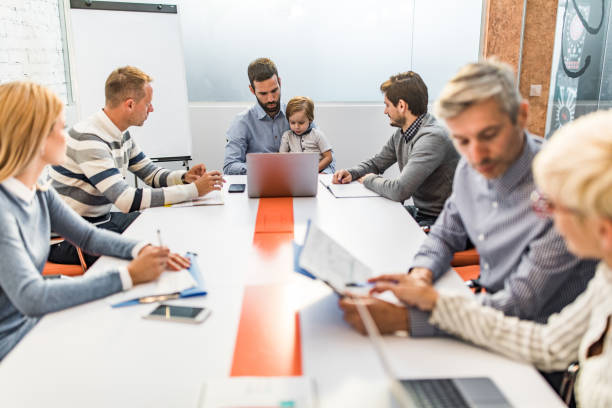 istock Business father and his small son using laptop on a meeting in a board room. 1129798849