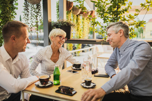 istock Happy business colleagues communicating while enjoying on a break in a cafe. 1129798989
