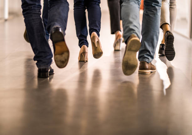 istock Rear view of unrecognizable colleagues running through hallway. 1129799641
