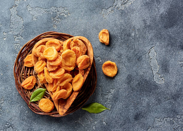 istock Dried apricots on gray concrete background with copy space. Top view. 1129800418