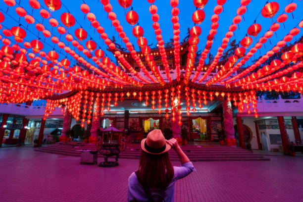 junge frau reiseleiter unterwegs und mit blick auf rote laternen dekorationen in chinesischen tempel - chinesische laterne stock-fotos und bilder