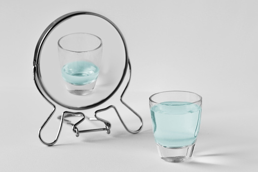 Full water glass looking in the mirror and seeing himself as an empty glass - Concept of pessimism
