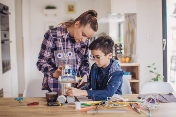 istock Boy making robot toy with his older sister 1129805209