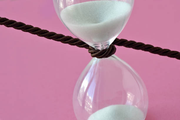 모래 시계-핑크 배경에 주위 코드의 클로즈업 중지 시간 개념 - biological clock 뉴스 사진 이미지