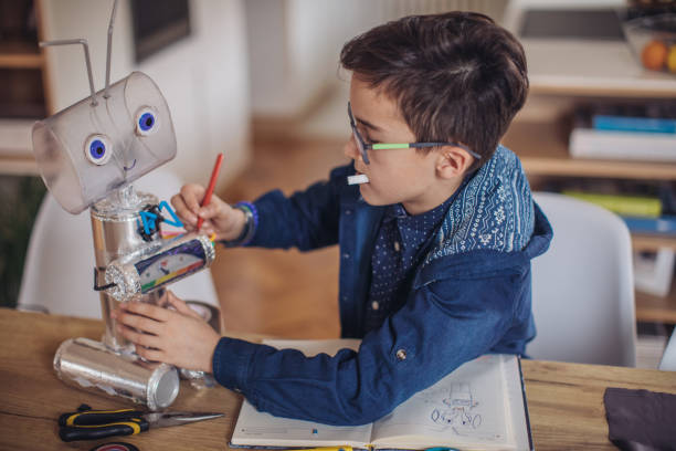 ragazzo che fa robot per il progetto scolastico - primary produce foto e immagini stock