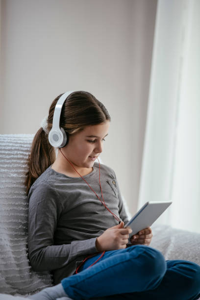 istock Girl using tablet and listening music 1129806672