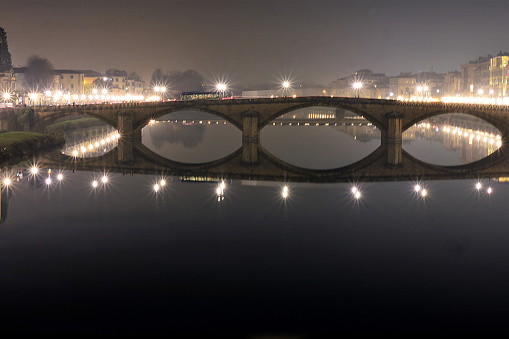 Florence, Italy - December 10 2016. Illuminated bridges of Florence. And 'evening and the river is full of reflections.