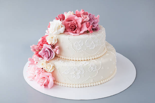 istock Two-tiered white wedding cake decorated with pink flowers 1129807567