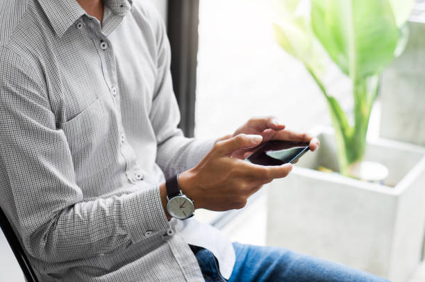 istock young asian man watching mobile smart phone - device technology and gadget concept 1129807942