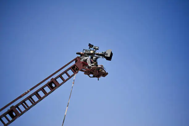 Close-Up of film making with a camera operator high up on a crane