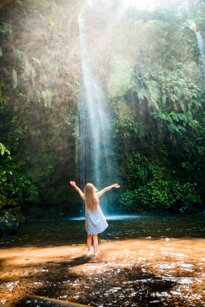 istock Little girl by the waterfalls 1129808355