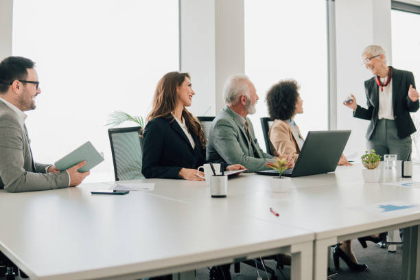 istock Senior woman with coworkers 1129809188