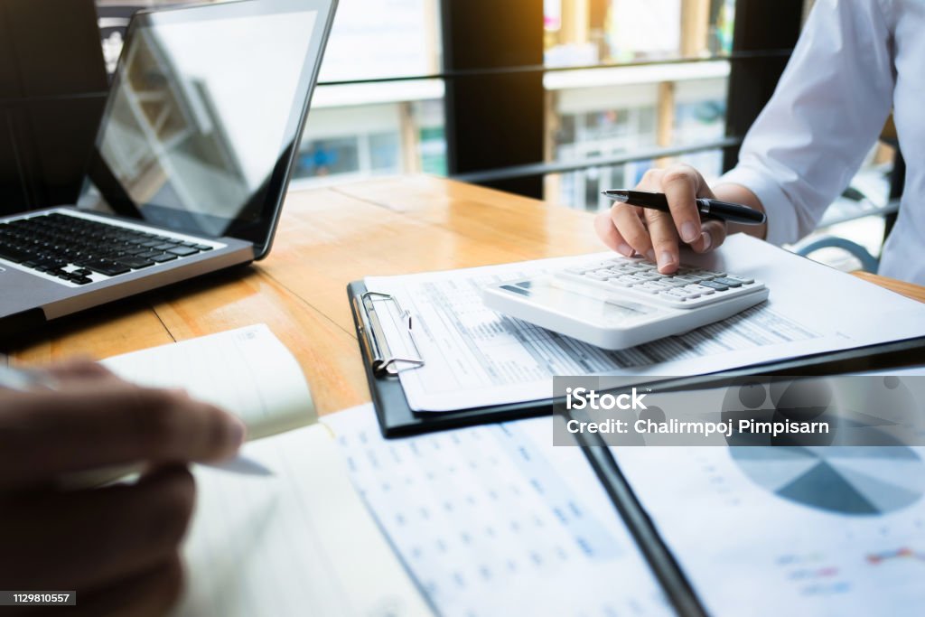 business audits using a calculator financial data investment fund at a workplace, wealth concept Finance Stock Photo