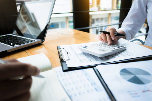 business audits using a calculator financial data investment fund at a workplace, wealth concept - massa imagens e fotografias de stock