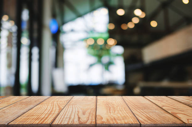 istock empty blank wooden table in front of blurred montage cafe house background 1129810849
