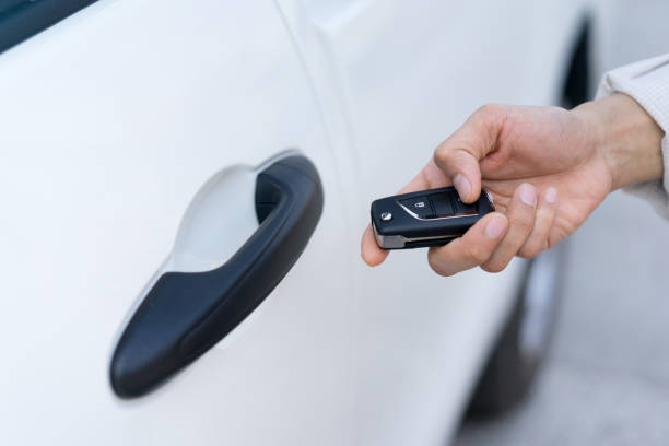istock close up driver man hand holding keyless of autonomous ecology car and using remote command via wireless function for unlock inside , future transportation technology concept 1129814068
