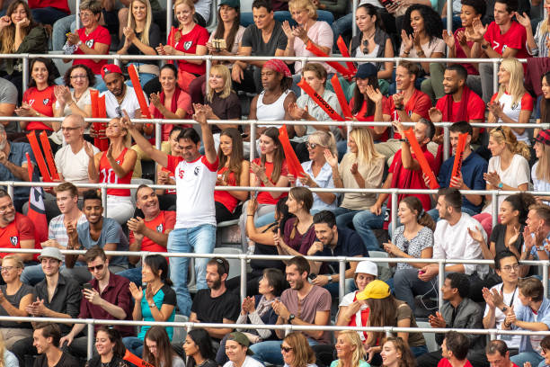 istock Group of spectators cheering in stadium 1129816071