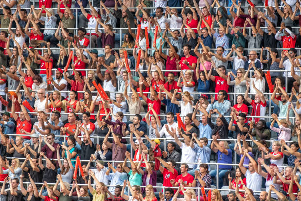 istock Group of spectators cheering in stadium 1129816092