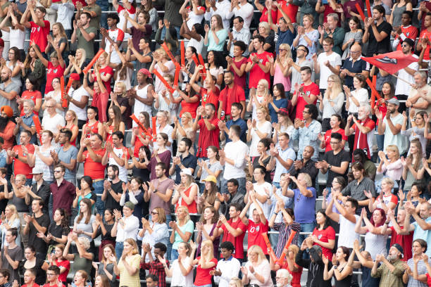 istock Group of spectators cheering in stadium 1129816095