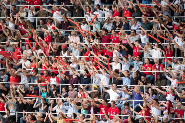 istock Group of spectators cheering in stadium 1129816109