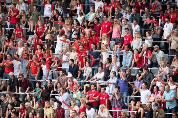 istock Group of spectators cheering in stadium 1129816112