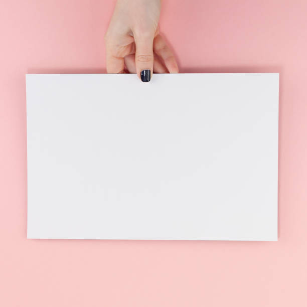 istock Woman hands with blank A4 paper sheet mockup 1129816272
