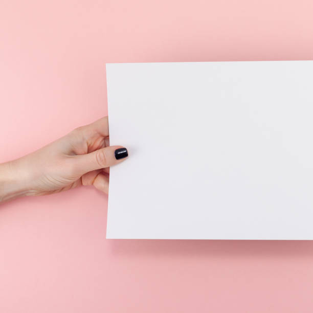 istock Woman hands with blank A4 paper sheet mockup 1129816279