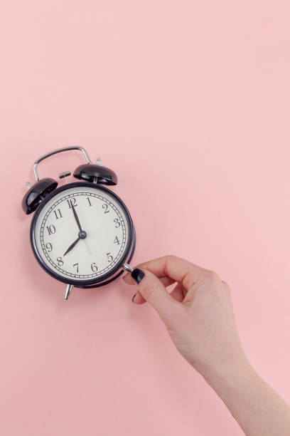 istock Female hand with alarm clock. Morning concept 1129816346