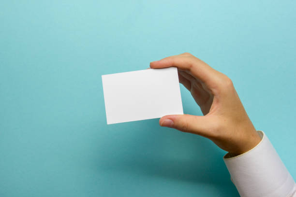 istock Hand holding white business card on white background 1129816594