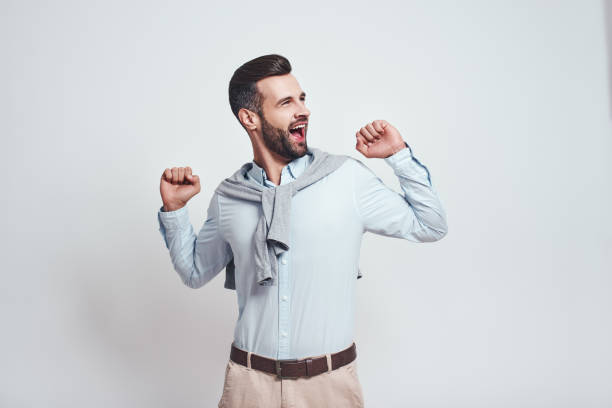 istock Try to hold on. Young bearded man is yawning and feeling tired in studio on a grey background 1129816836