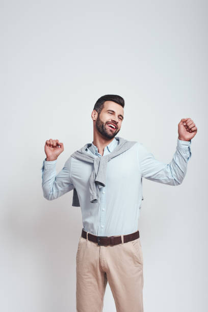 istock So tired. Cute and young man is feeling sleepy and tired after work while standing in studio on a grey background 1129816837