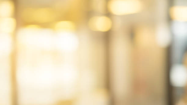 abstract blur inside modern architecture loft cozy interior shopping mall or department store with light bokeh fro design concept