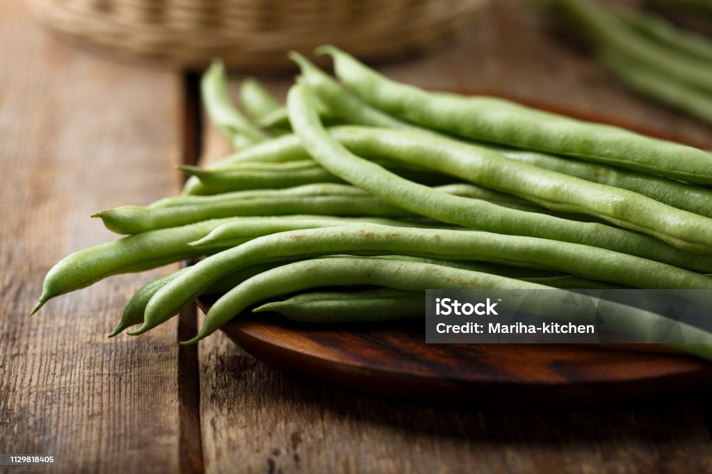Raw green beans Raw green beans on wooden desk Green Bean Stock Photo