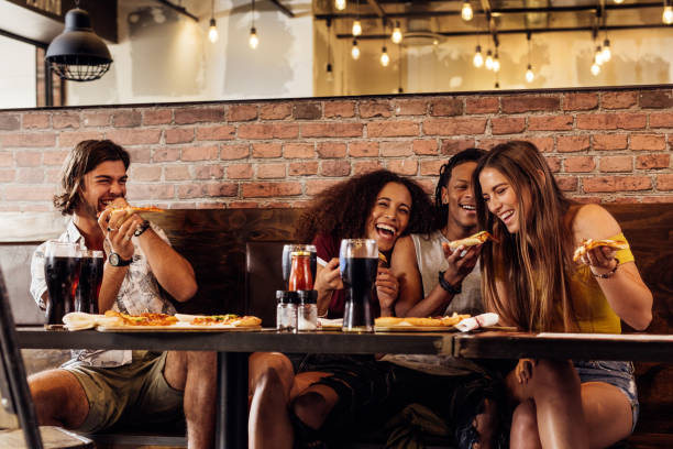 istock Group of friends having pizza at restaurant 1129818697