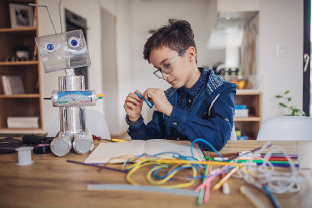 istock Boy making robot of recycling material for school project 1129818998