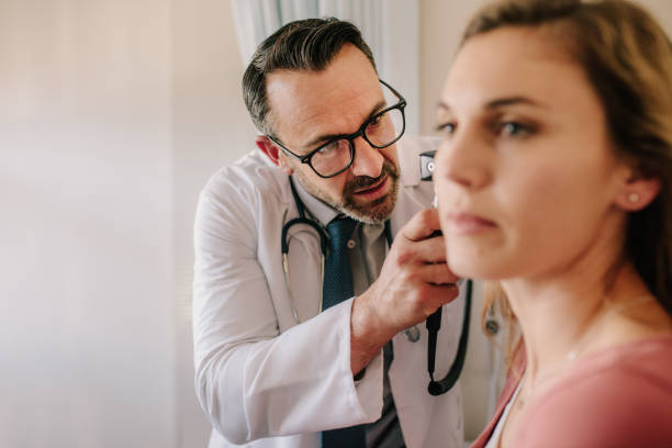 istock ENT physician checking patient's ear with an instrument 1129819752